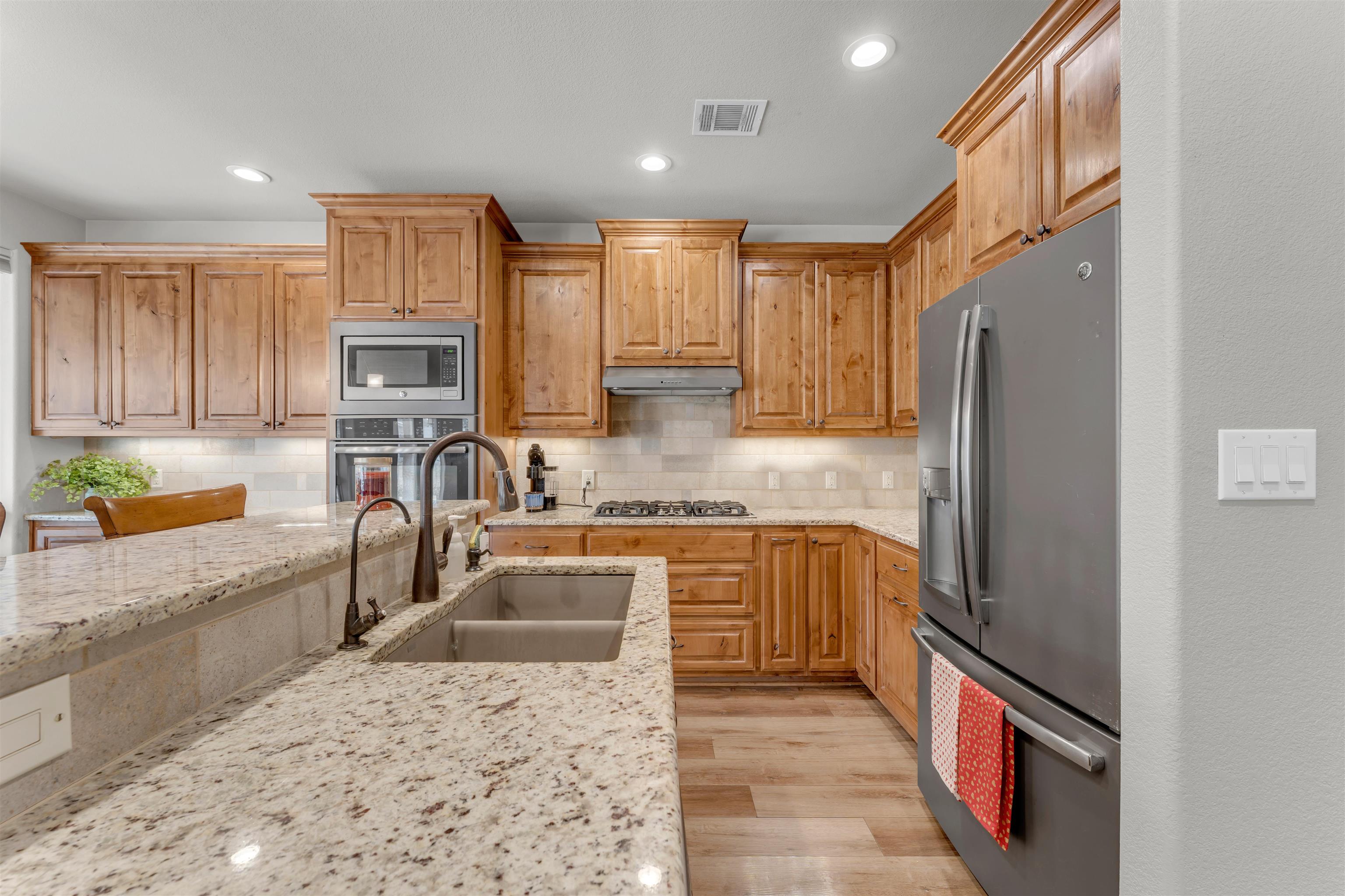 227 Watkins Point Kingsland, TX 78639 - Photo 10 of 30 a kitchen with stainless steel appliances granite countertop a sink stove and refrigerator