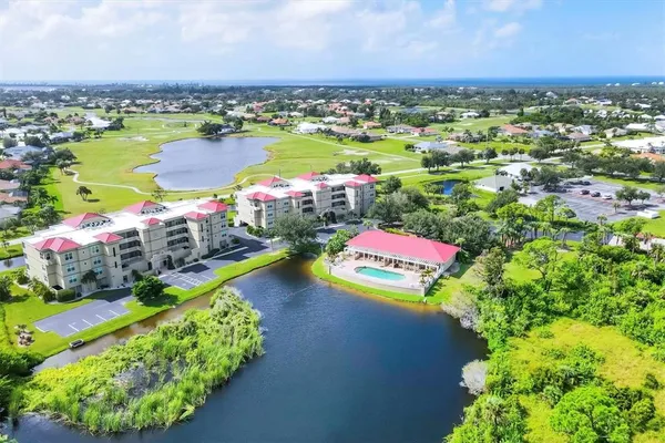 an aerial view of a house with a garden and lake view