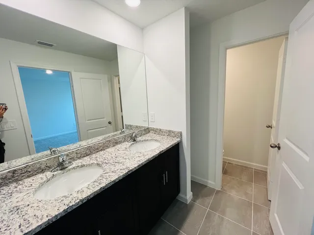 a bathroom with a granite countertop sink mirror and a shower
