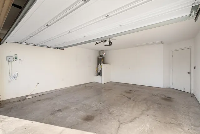 a view of a blue house with a small yard and wooden fence