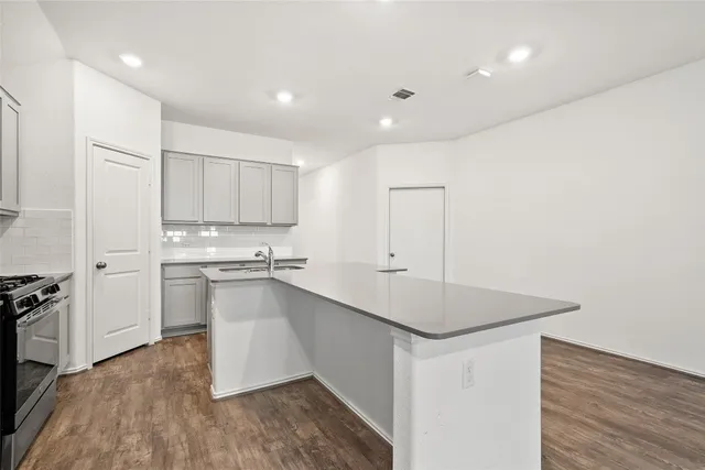 a kitchen with stainless steel appliances granite countertop a refrigerator a stove and a sink