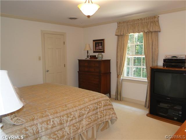 12811 Singer Road Midlothian, VA 23112 - Photo 8 of 12 a bedroom with a bed and a flat tv screen on dresser