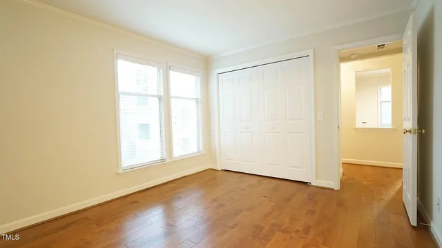 an empty room with wooden floor and a window