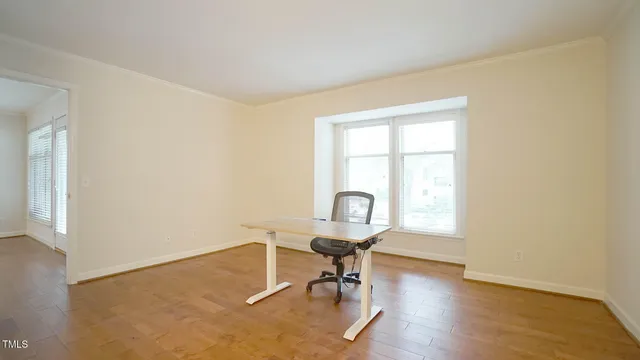 a view of a workspace with wooden floor and a window