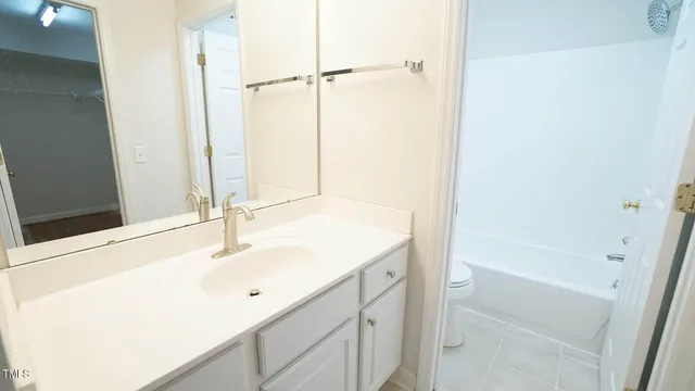a bathroom with a tub sink vanity and a mirror