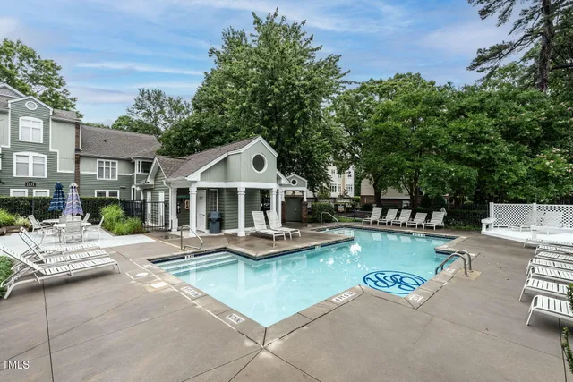 a view of a patio with couches and chairs under an umbrella