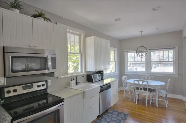 a kitchen with stainless steel appliances granite countertop a stove a sink and a microwave