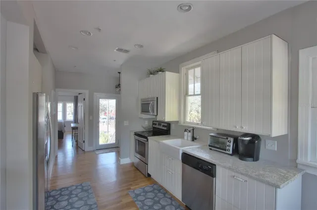 a kitchen with stainless steel appliances granite countertop a sink stove and refrigerator