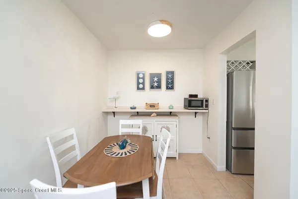 a kitchen with stainless steel appliances granite countertop a refrigerator a stove a sink a dining table and chairs