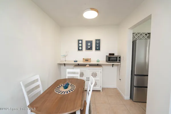 a living room with a sink and a refrigerator
