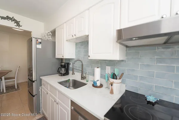 a kitchen with a sink a stove and chairs