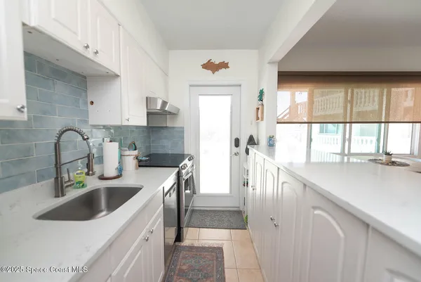 a kitchen with stainless steel appliances granite countertop a sink a counter space and a window