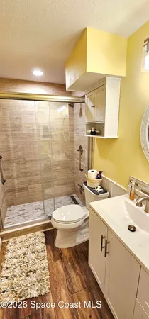 a bathroom with a sink a toilet and shower