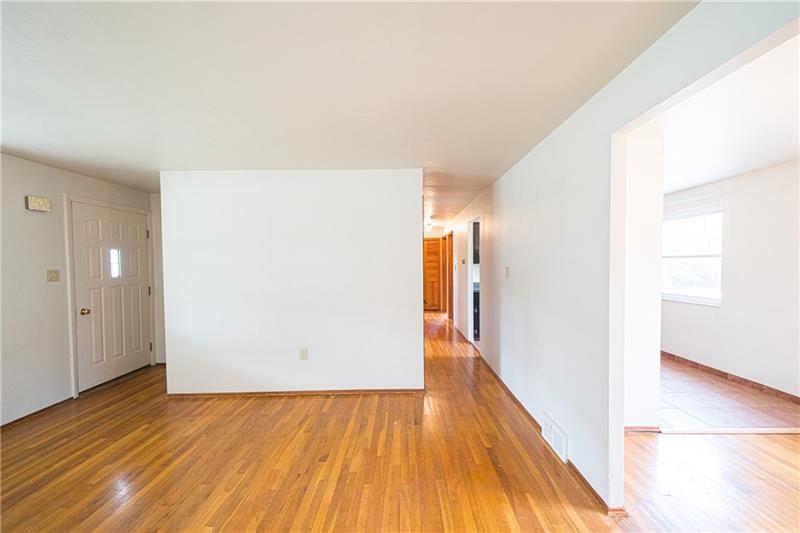 ANOTHER VIEW OF THE LIVINGROOM AND THE HALL TO THE BEDROOM AREA.