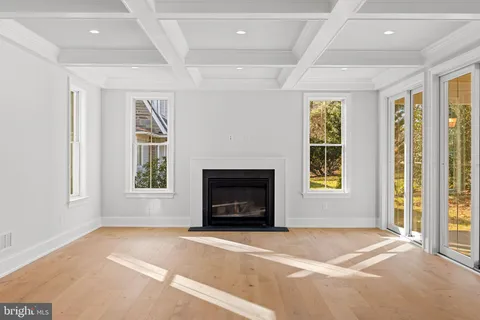 a large kitchen with stainless steel appliances a large counter top a refrigerator a sink and a wooden floors