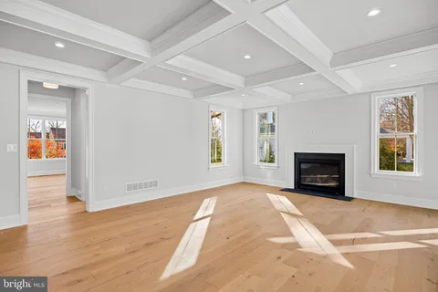 a view of a hallway with wooden floor and a living room