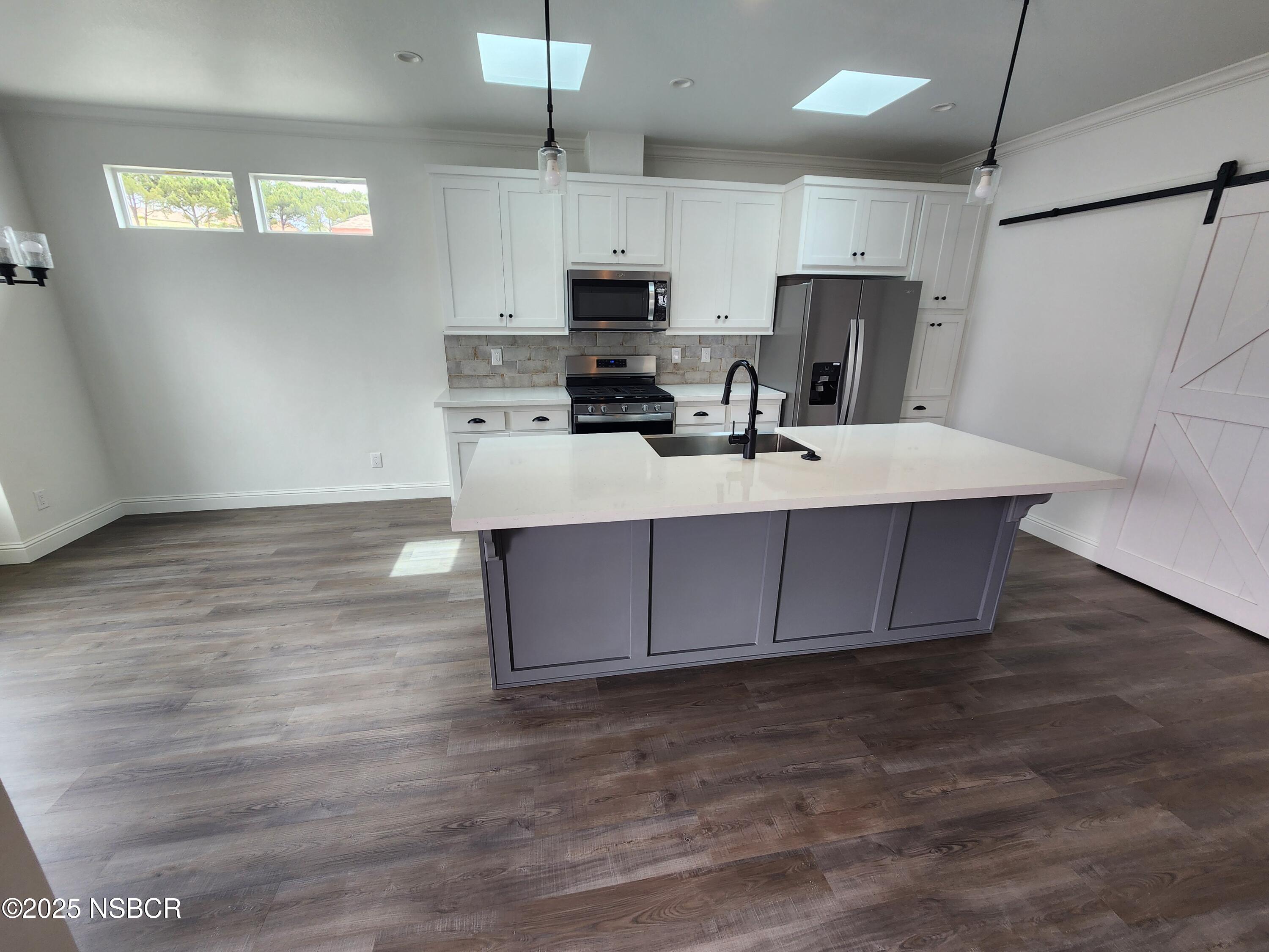 87 Rio Vista Solvang, CA 93463 - Photo 6 of 18 a kitchen with stainless steel appliances a sink a stove a microwave a refrigerator a center island and cabinets
