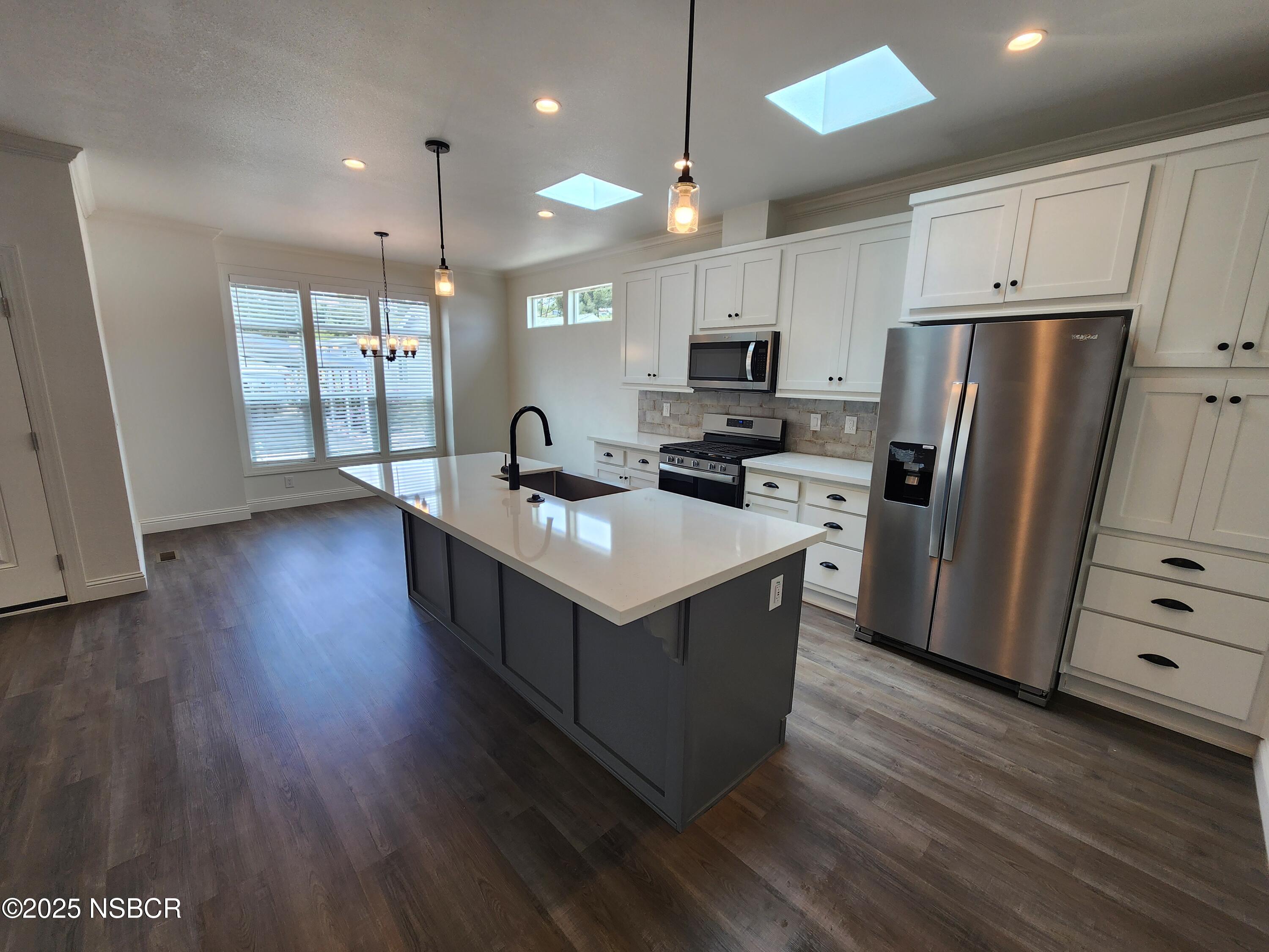 87 Rio Vista Solvang, CA 93463 - Photo 7 of 18 a kitchen with kitchen island wooden floors appliances and cabinets