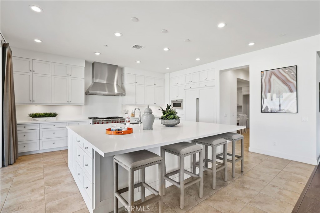 74 Egret Irvine, CA 92618 - Photo 15 of 74 a white kitchen with stainless steel appliances granite countertop a stove a sink a dining table and chairs