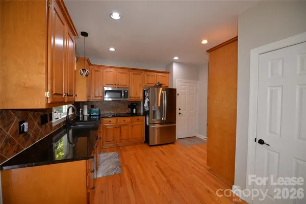 a large kitchen with lot of wooden cabinets and stainless steel appliances