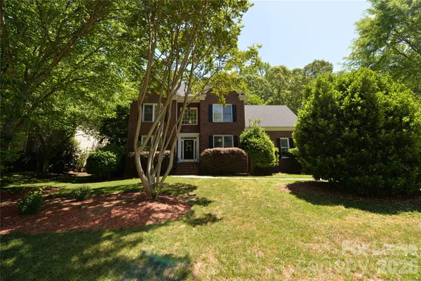 a view of a house with yard and tree s