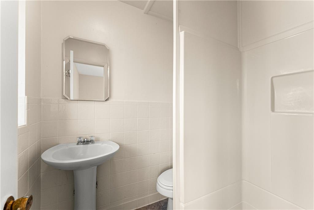 660 Honeysuckle Road Gainesville, GA 30501 - Photo 14 of 43 a bathroom with a sink a toilet and mirror