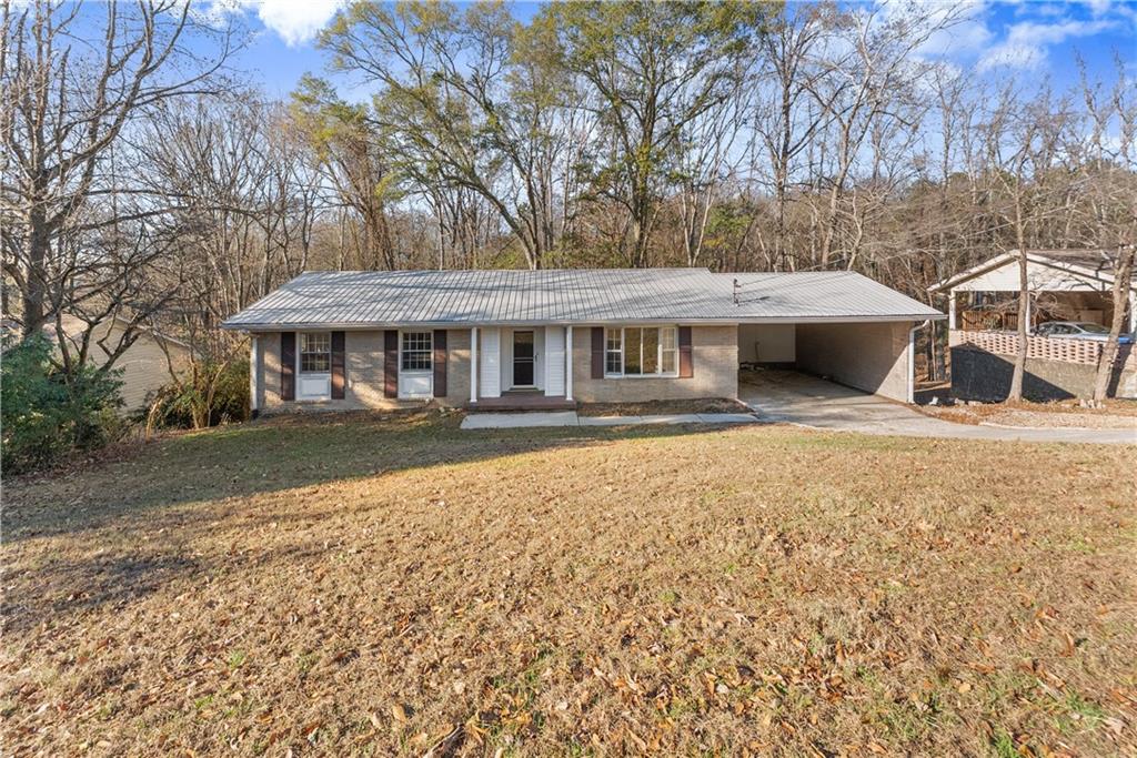 660 Honeysuckle Road Gainesville, GA 30501 - Photo 3 of 43 a front view of a house with a yard covered with snow and trees