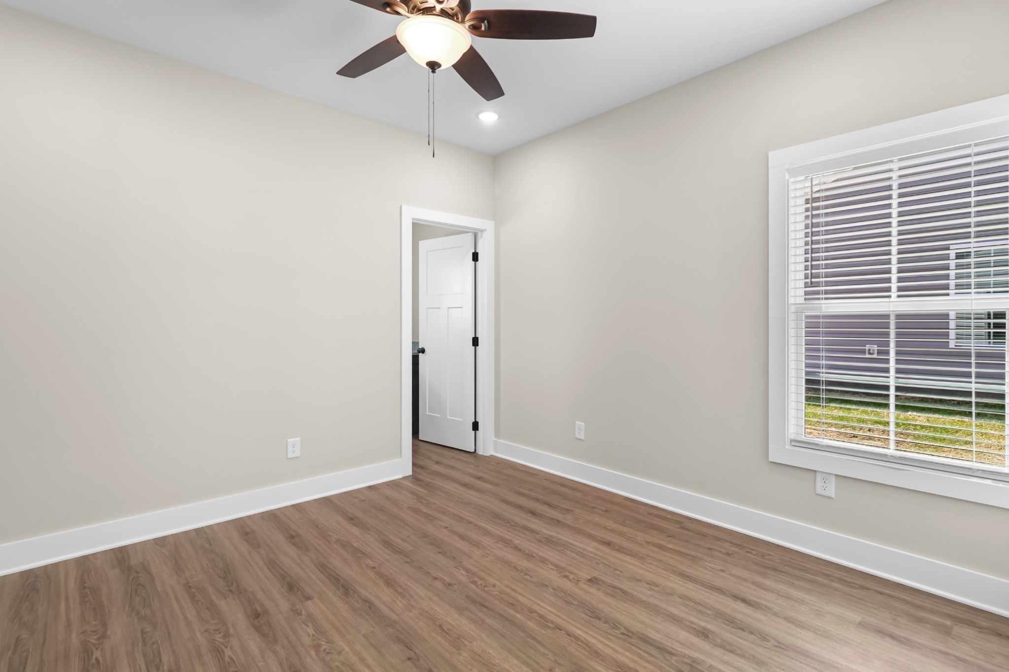 1004 Oak Street, Unit B Portland, TN 37148 - Photo 14 of 29 an empty room with wooden floor chandelier fan and windows