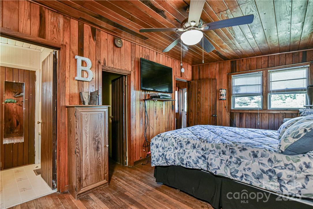 415 Weaverville Road Asheville, NC 28804 - Photo 21 of 47 a bedroom with a bed window and a flat screen tv