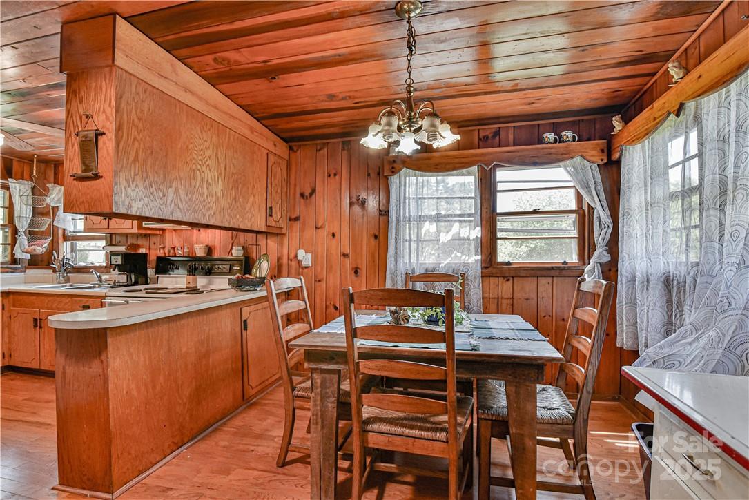 415 Weaverville Road Asheville, NC 28804 - Photo 26 of 47 a view of a dining room with furniture a chandelier and wooden floor