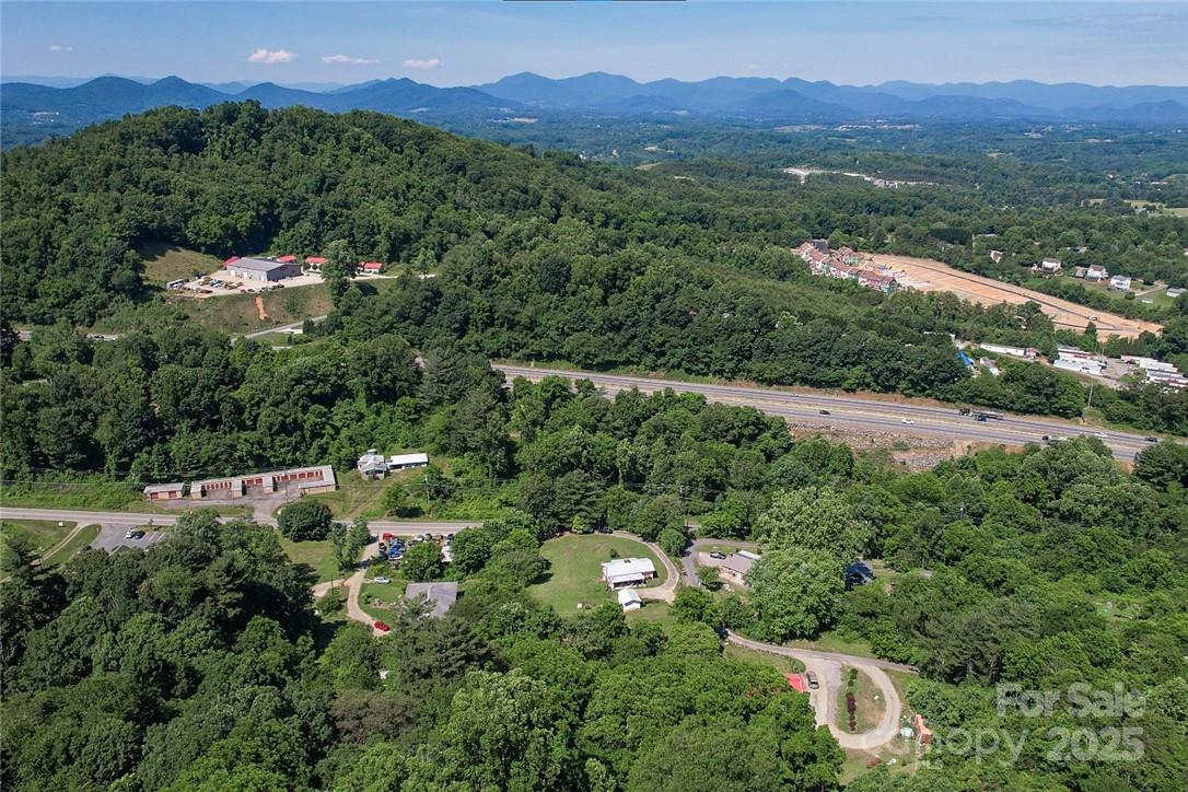 415 Weaverville Road Asheville, NC 28804 - Photo 47 of 47 a view of a lush green hillside and a building in the background