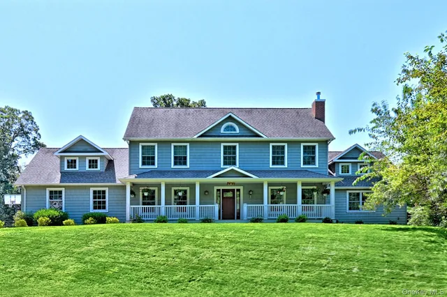 a view of a brick house with a big yard and large trees