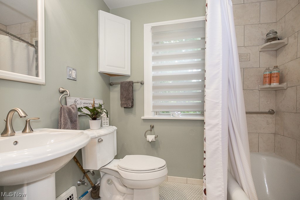 7070 Ridge Road Parma, OH 44129 - Photo 12 of 28 Full bathroom with shower / bathtub combination with curtain, toilet, sink, and tile patterned floors