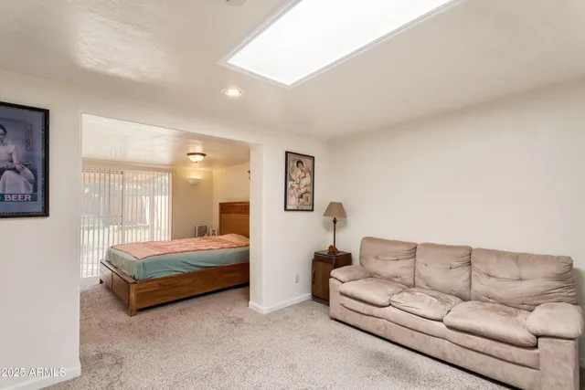 a spacious bedroom with a bed couch and window