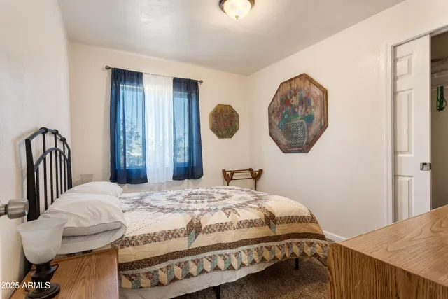 a bedroom with a bed and a painting on the wall