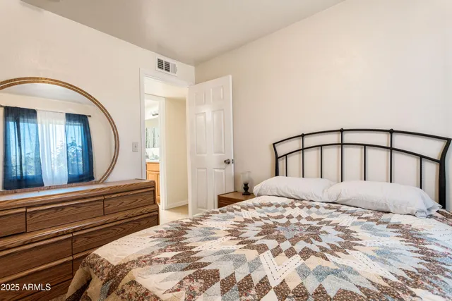 a bedroom with a bed and a mirror on dresser