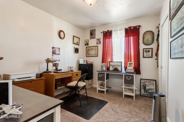 a view of a workspace with furniture and a window
