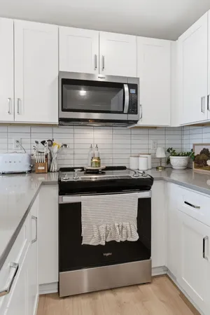 a kitchen with stainless steel appliances granite countertop a stove a microwave a sink and cabinets