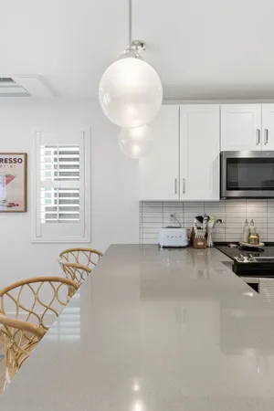 a kitchen with stainless steel appliances a white cabinets and a stove top oven