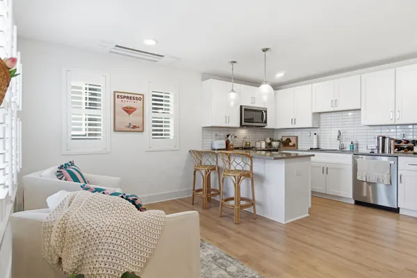 a kitchen with granite countertop white cabinets and white appliances