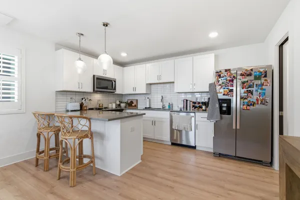 a kitchen with stainless steel appliances granite countertop a refrigerator a stove a sink and a microwave