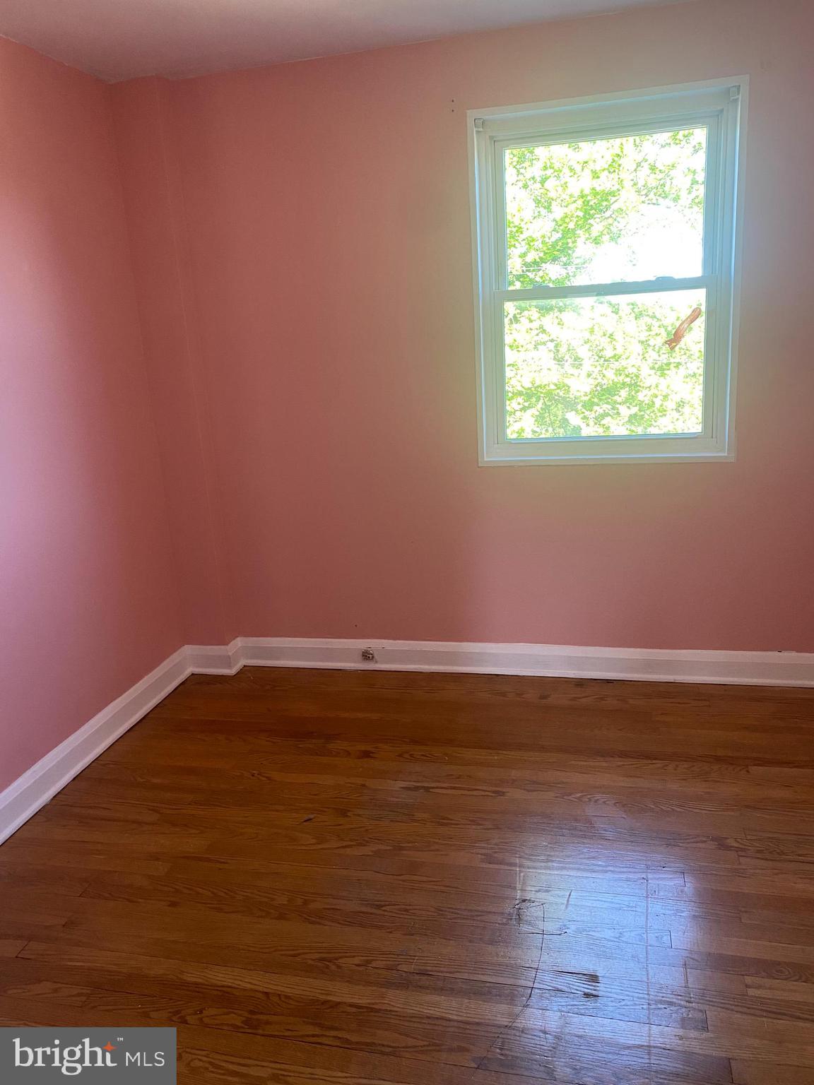906 Masefield Road Baltimore, MD 21207 - Photo 13 of 22 a view of an empty room with wooden floor and a window
