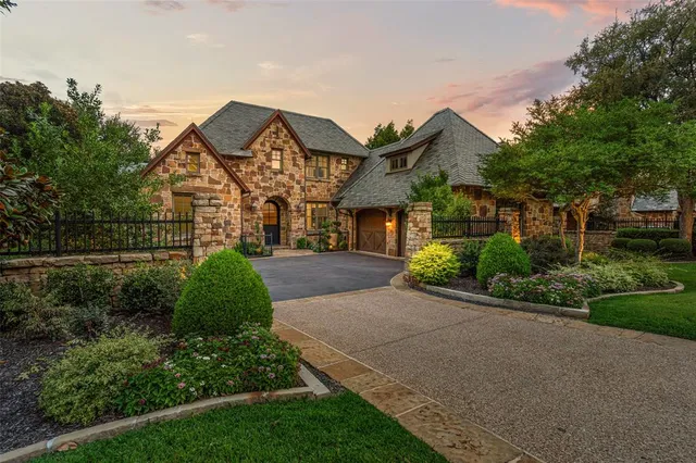 a view of a white house next to a yard with big trees
