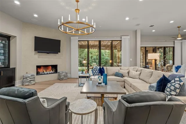 a view of a dining room and livingroom with furniture wooden floor and a chandelier