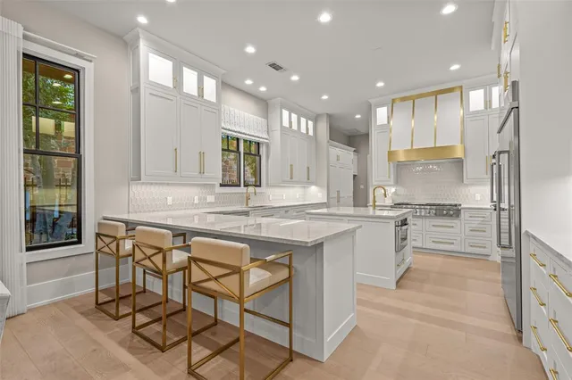 a kitchen with stainless steel appliances granite countertop a table chairs sink and cabinets