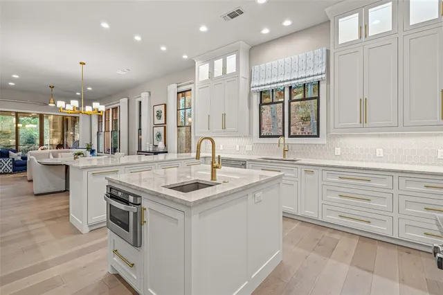 a large kitchen with stainless steel appliances lots of counter space and a sink