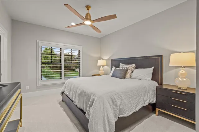 a bed room with a bed and a ceiling fan