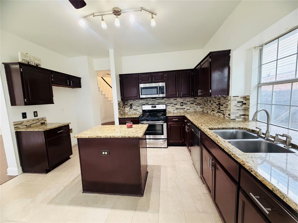 434 Moonlight Way Irving, TX 75063 - Photo 8 of 29 a kitchen with stainless steel appliances granite countertop a sink stove and refrigerator