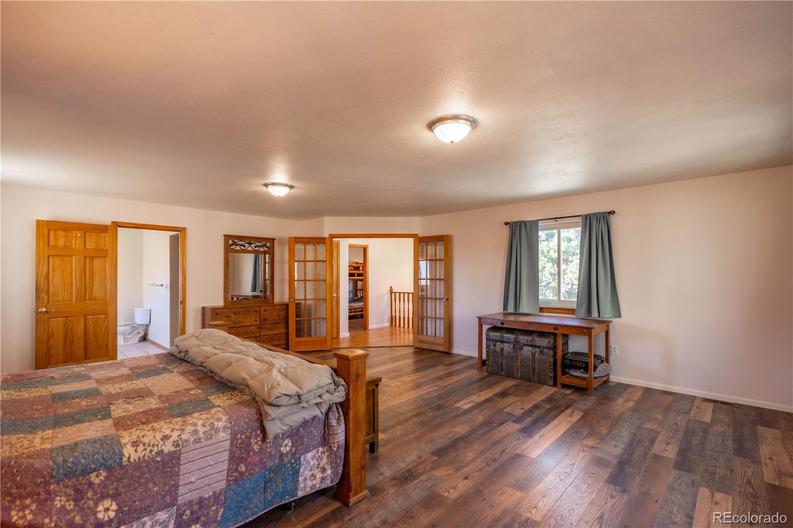 109 Heide Road Shawnee, CO 80475 - Photo 16 of 26 a spacious bedroom with a bed and wooden floor