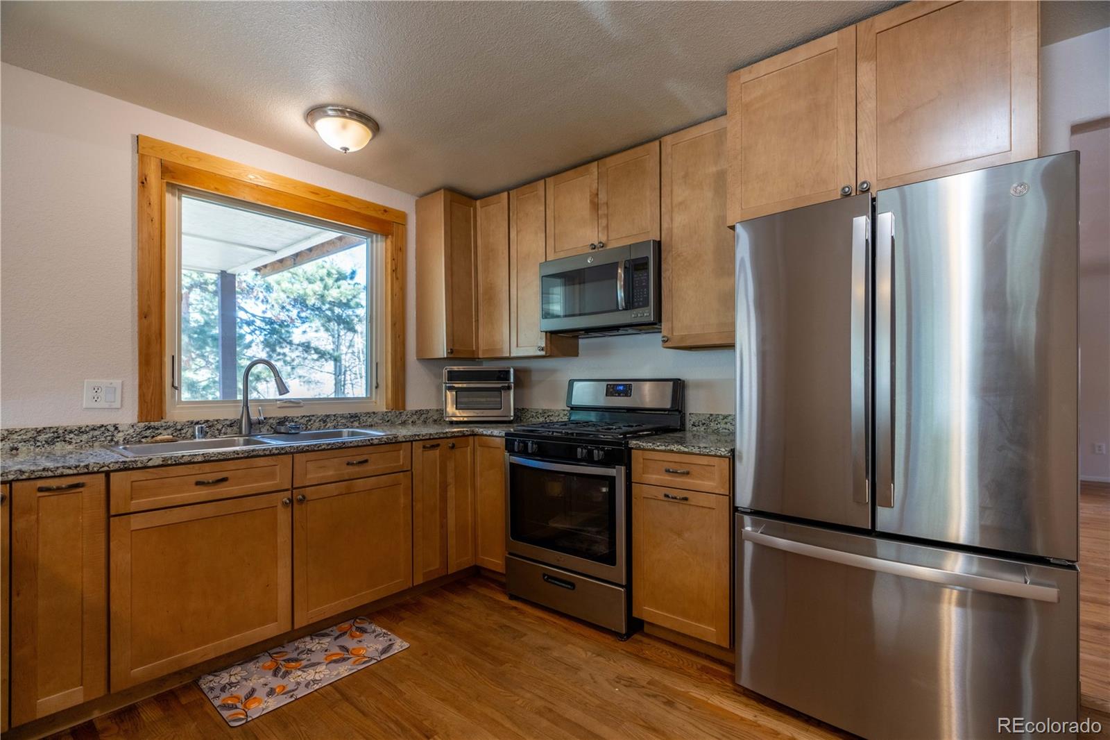 109 Heide Road Shawnee, CO 80475 - Photo 2 of 26 a kitchen with stainless steel appliances granite countertop a refrigerator a stove a sink and a window
